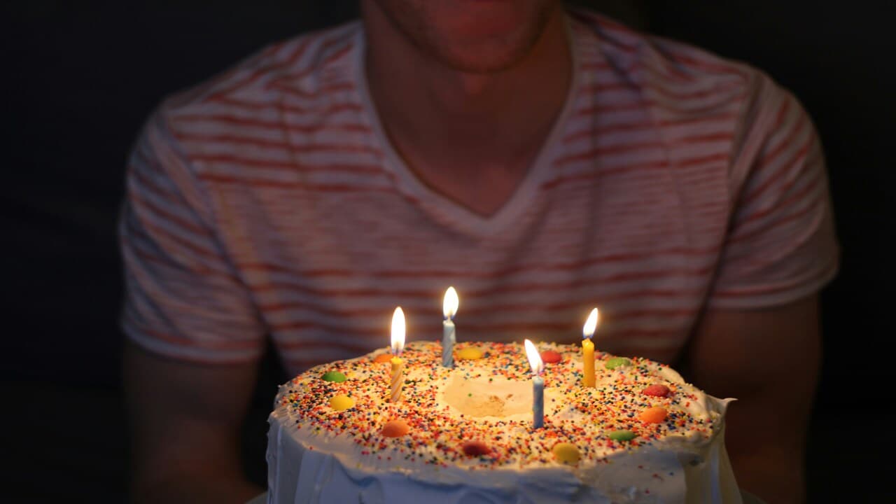 A man holding a birthday cake.