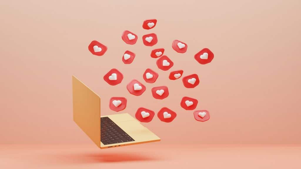 A laptop with hearts coming out of it.