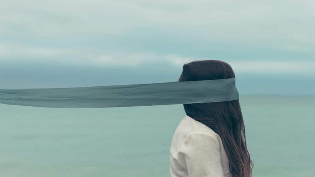 A woman with her face covered.
