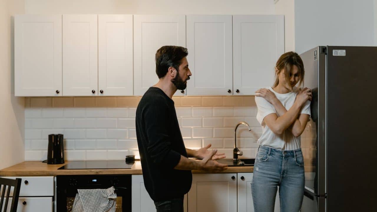 Man pointing out flaws while partner looks emotionally hurt.