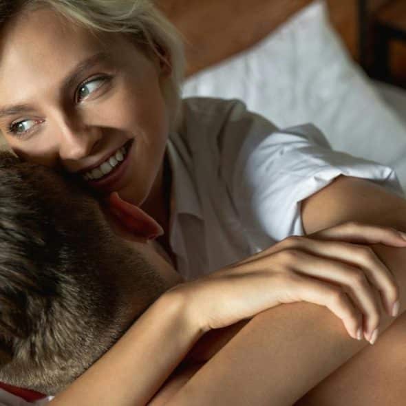 A couple embracing in bed.