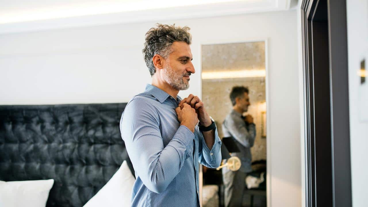 A man posing in front of a mirror.