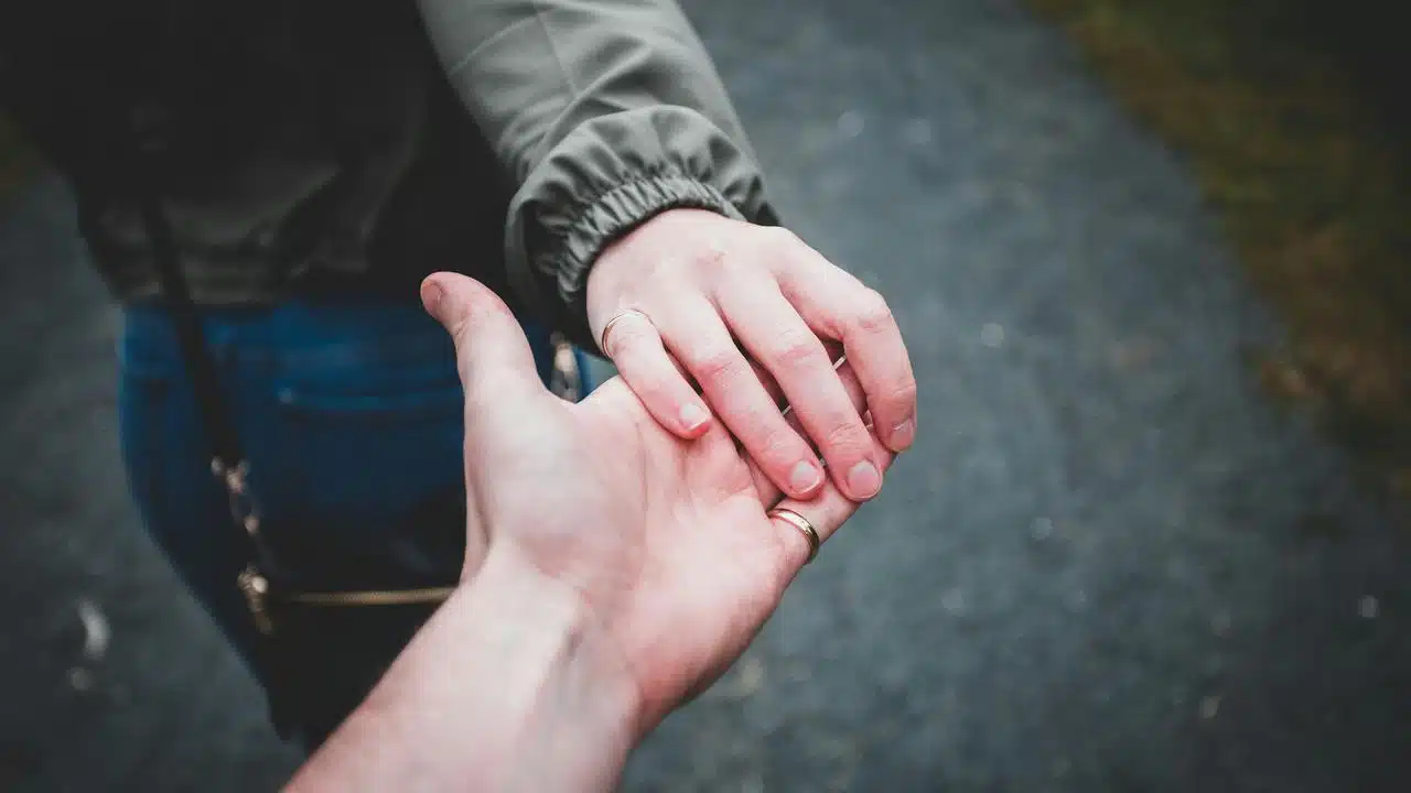 A couple holding hands outside.