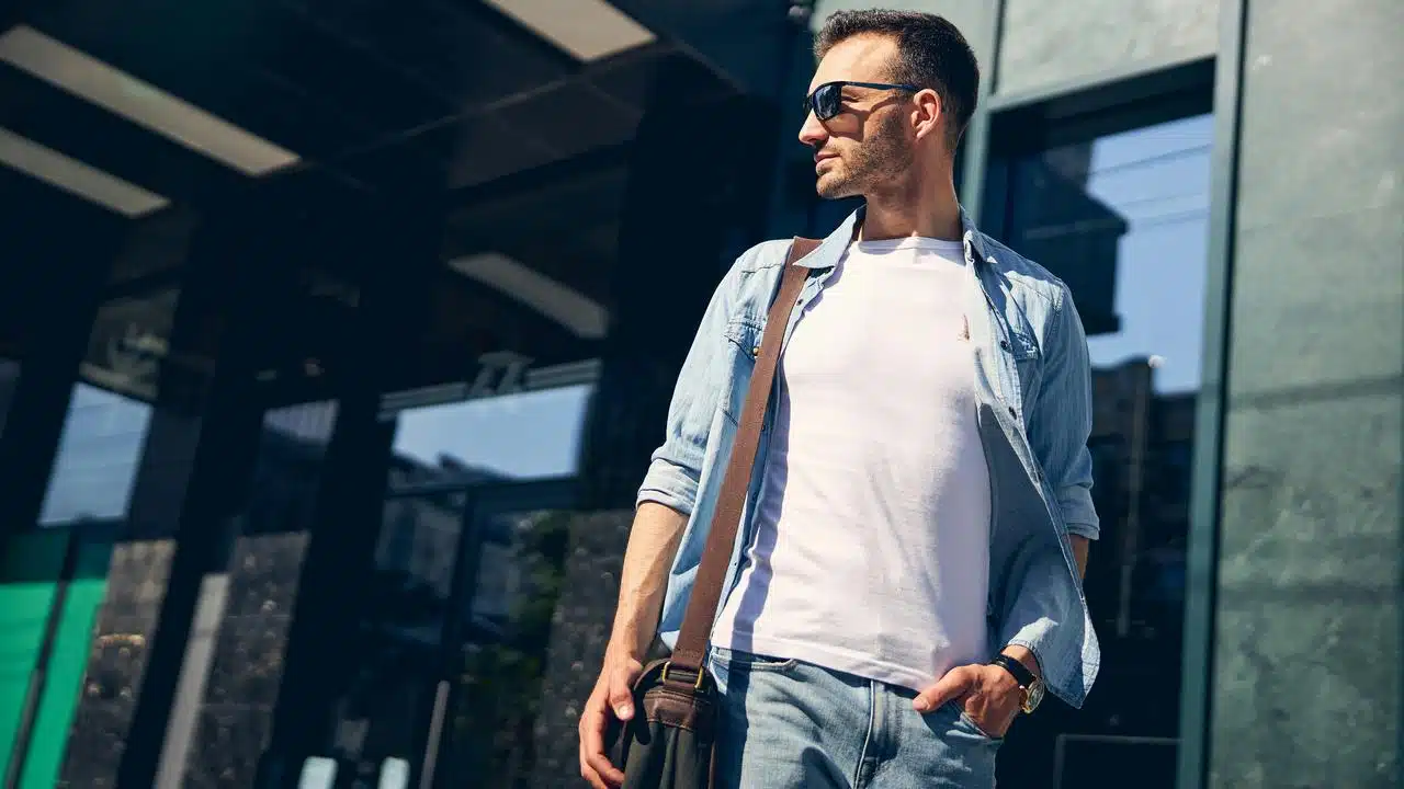 Young man in a casual outfit carrying a bag.