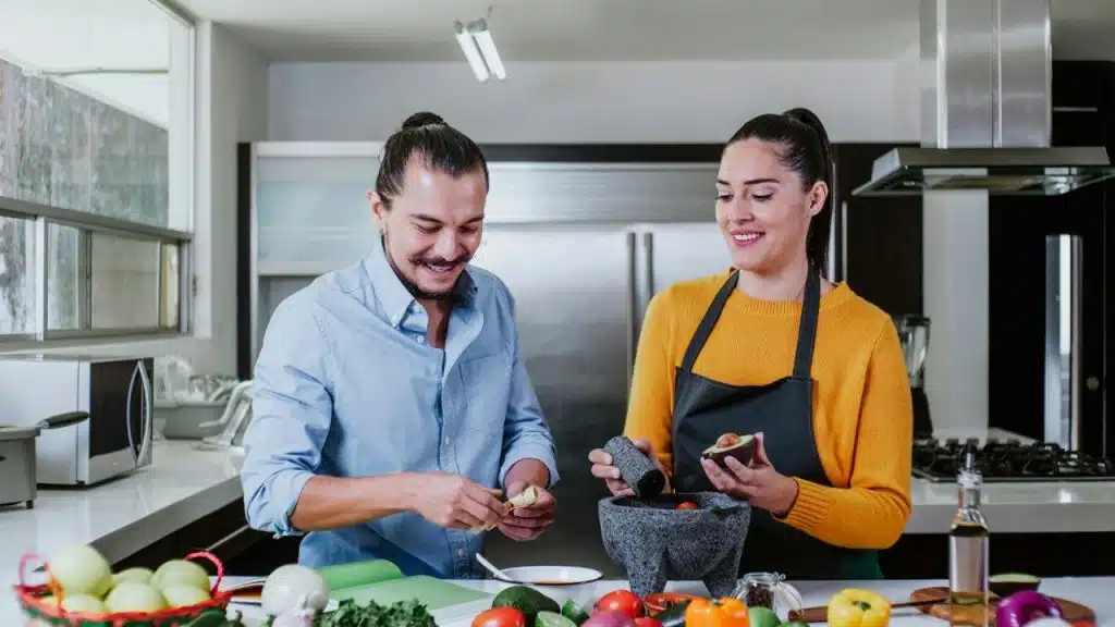 A man and woman prepare food together in a modern kitchen.