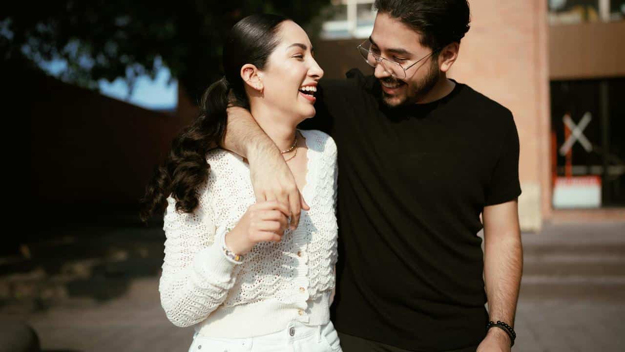 A smiling couple walking arm in arm.