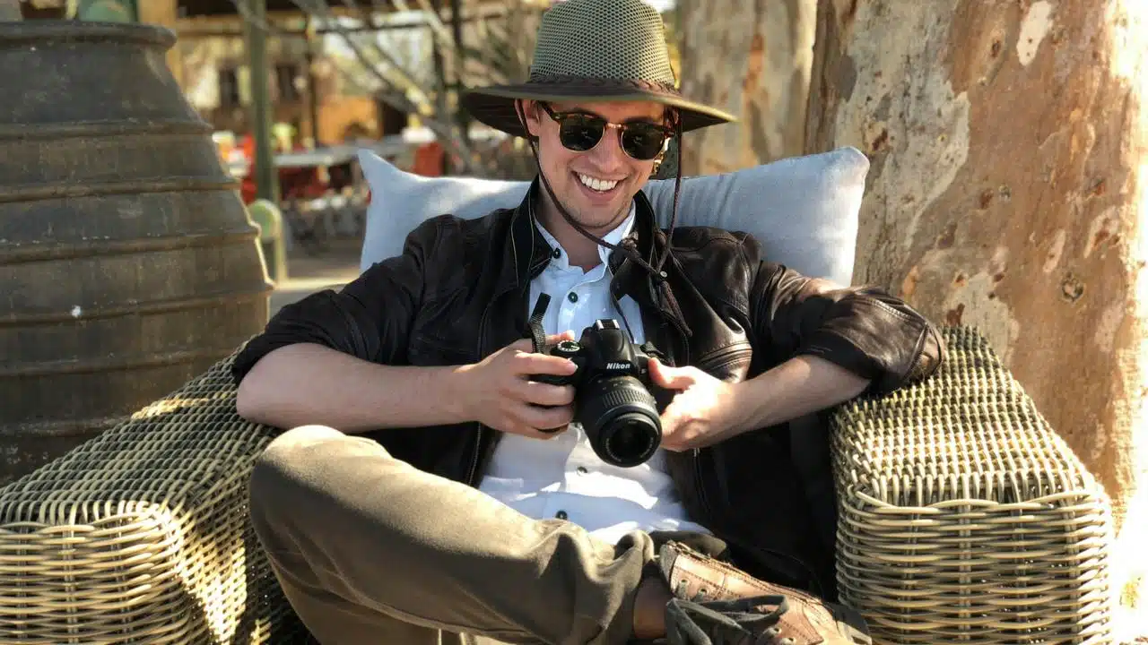 A man smiling while holding a camera.
