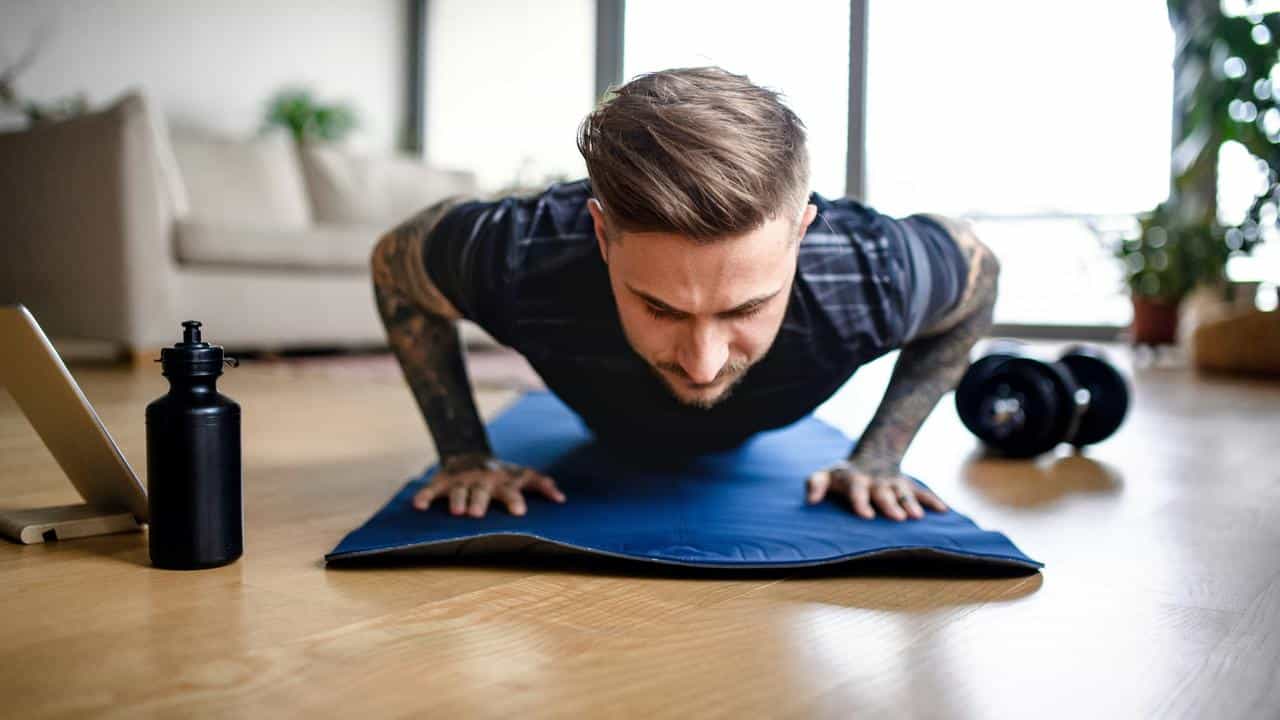 A man doing push-ups on a yoga mat.