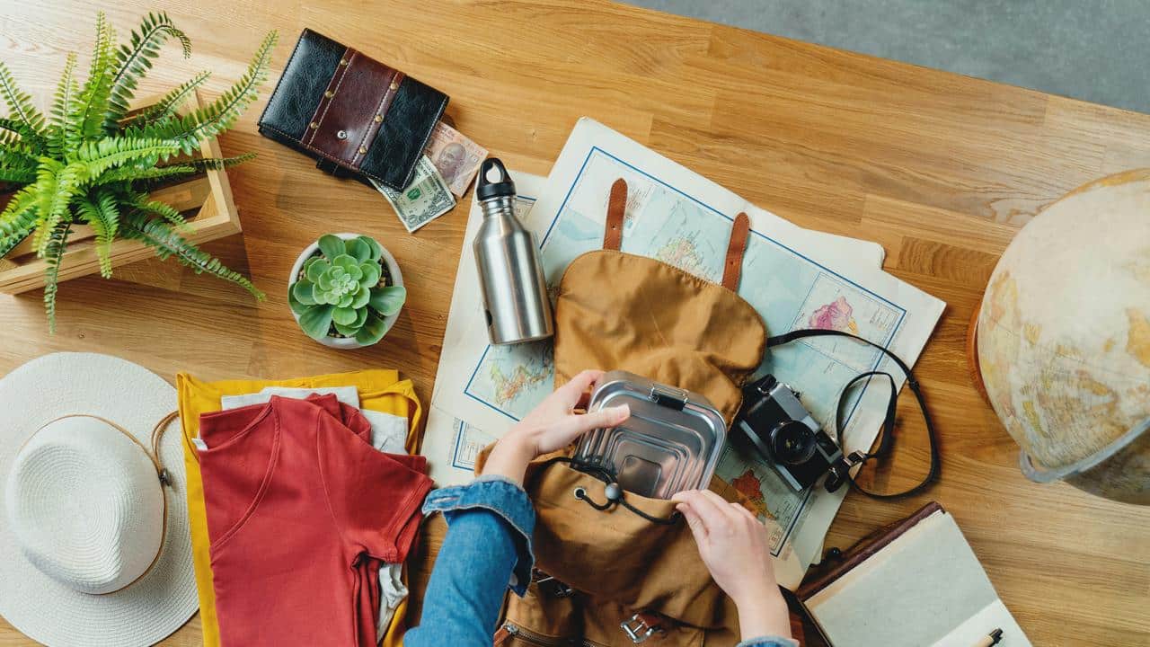 A person packing a backpack for travel.