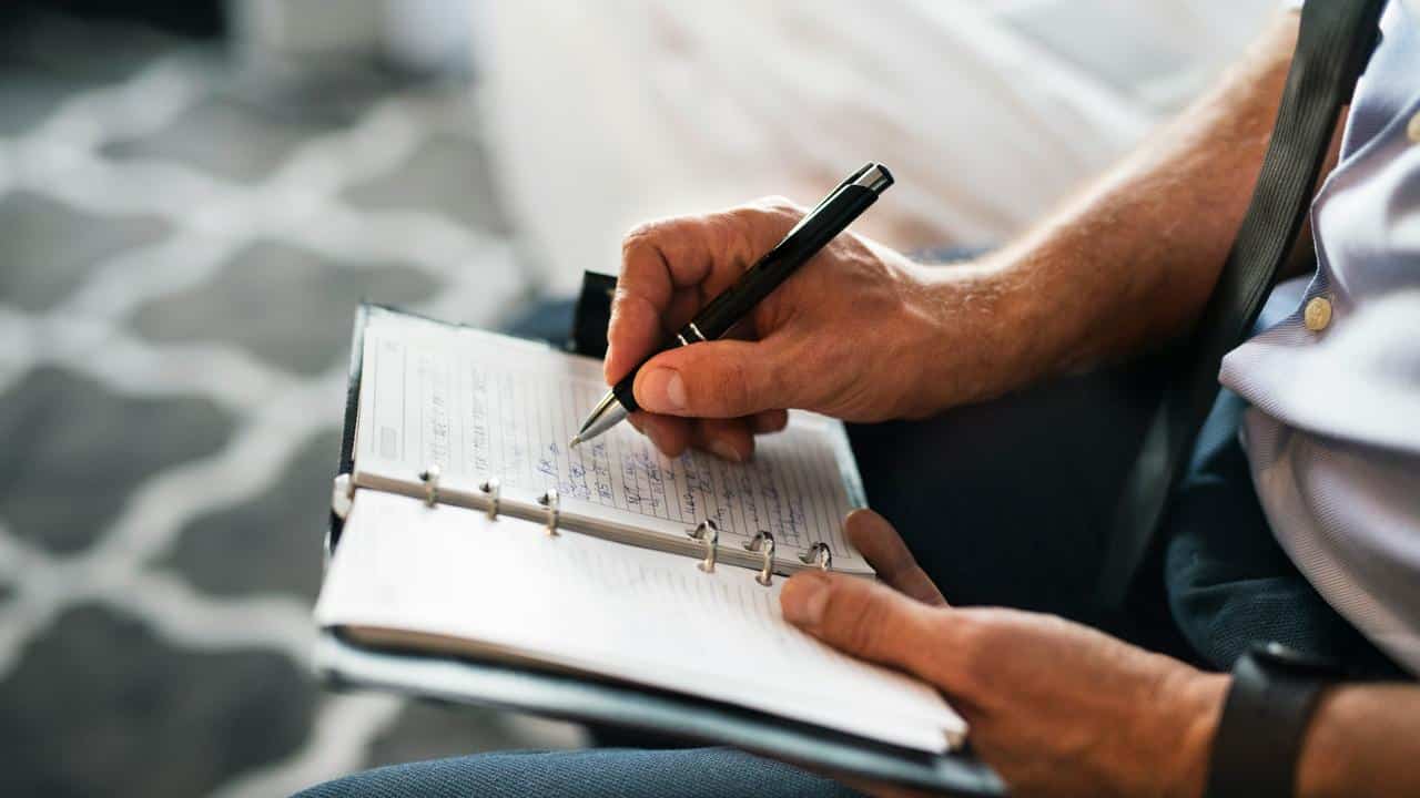A person writing in a planner.