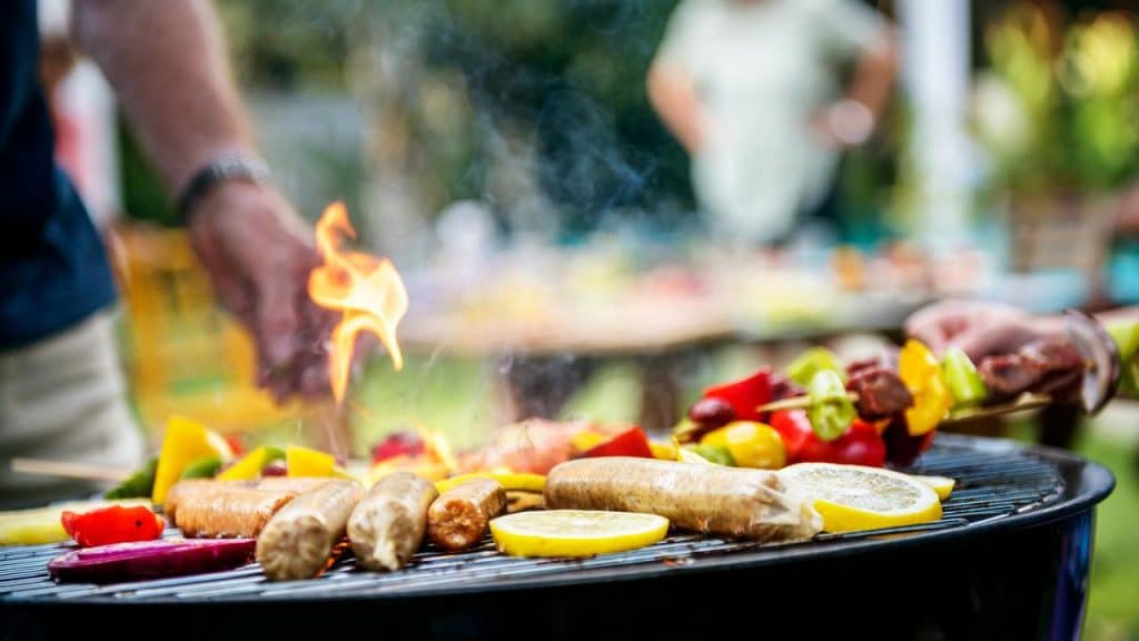A barbecue with sausages and vegetables.