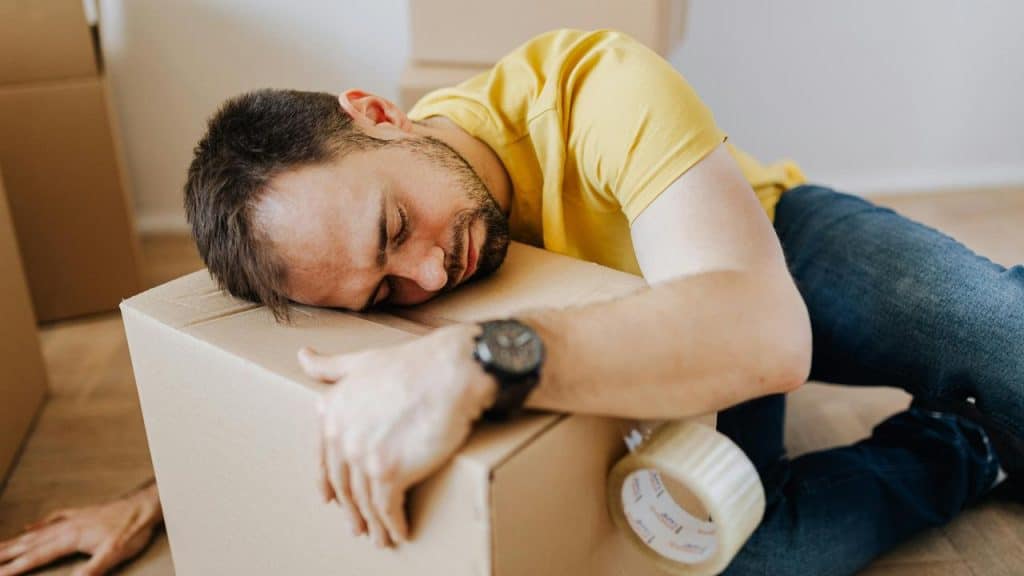 A man sleeping on a cardboard box.