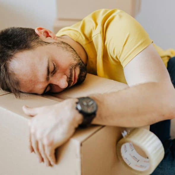 A man sleeping on a cardboard box.