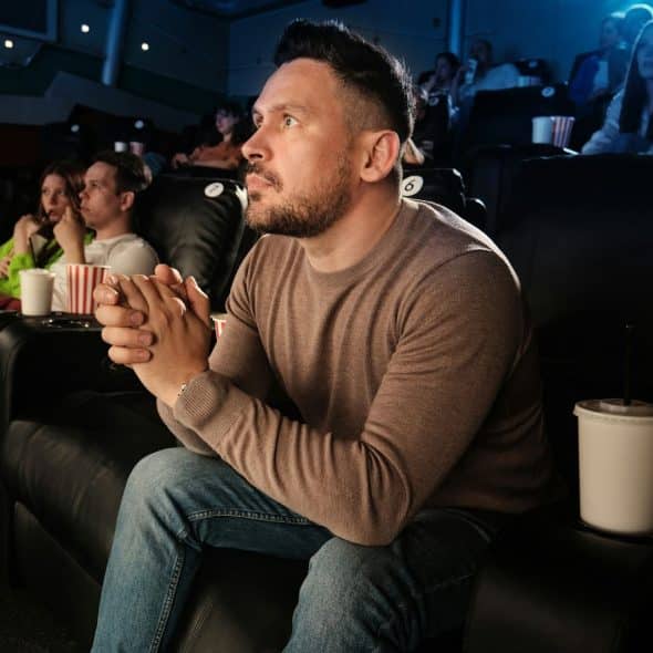 A man at the cinema watching a movie