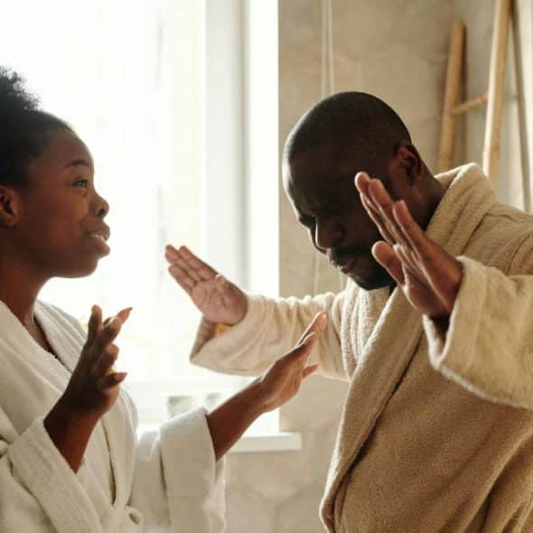 A couple in bathrobes in what appears to be a bathroom, arguing.