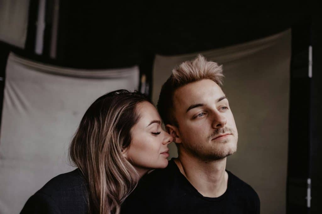 A woman kissing a man’s neck