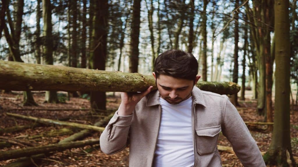 A man carrying a wood log