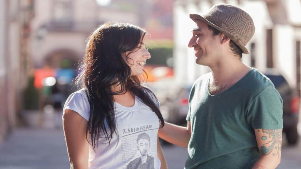 A couple smiling at each other outdoors