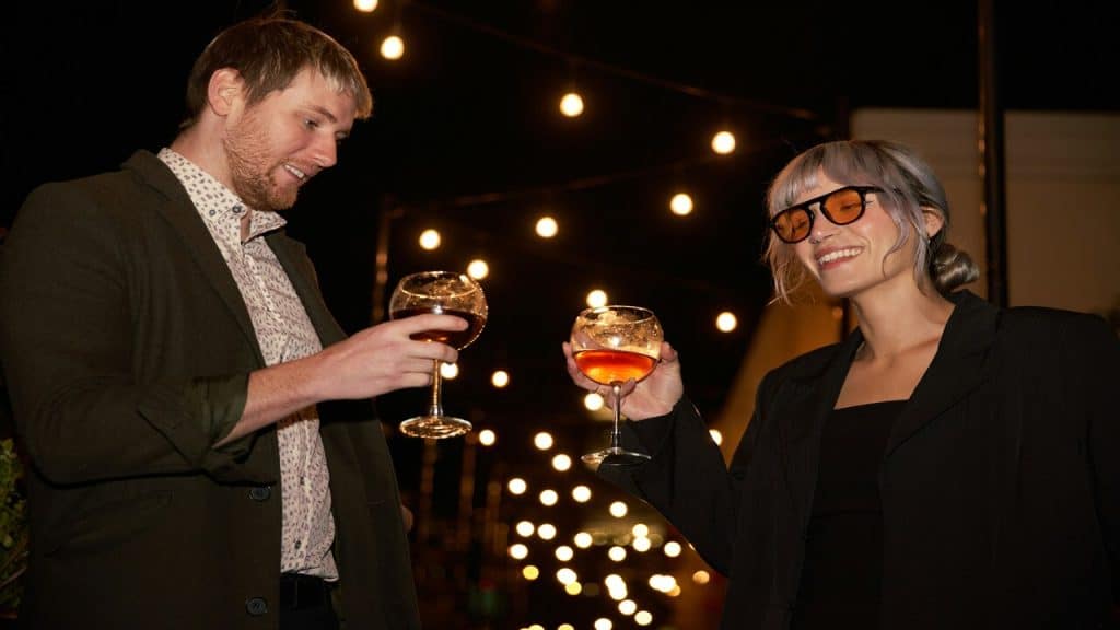 A couple toasting their wine glasses together