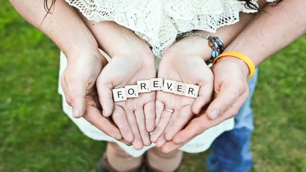A couple holding the word “forever” in their hands.
