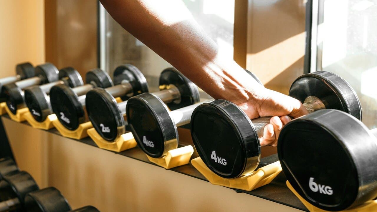 A hand grabbing a barbell.