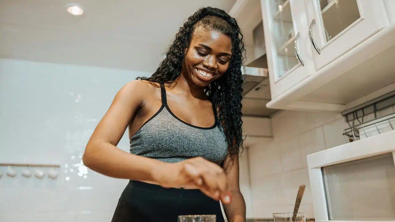 A woman smiling while preparing food.