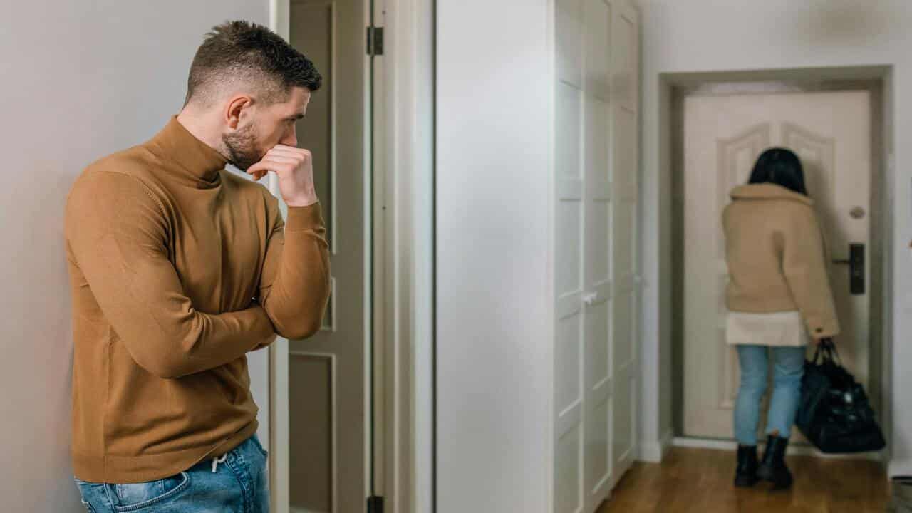 A woman walking away as husband looks.