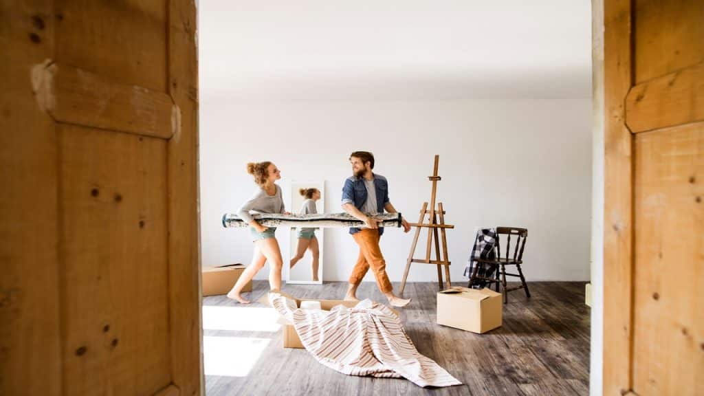 A couple carrying a carpet together