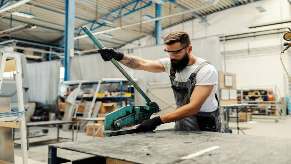 A mechanic cutting a metal part