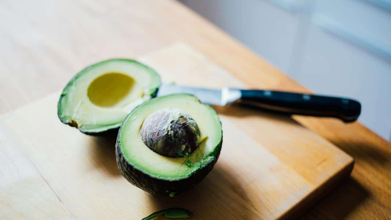 A sliced avocado on a cutting board.