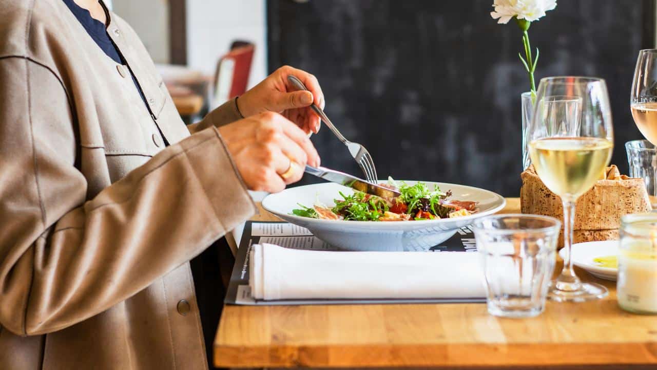 A person eating a salad at a restaurant.