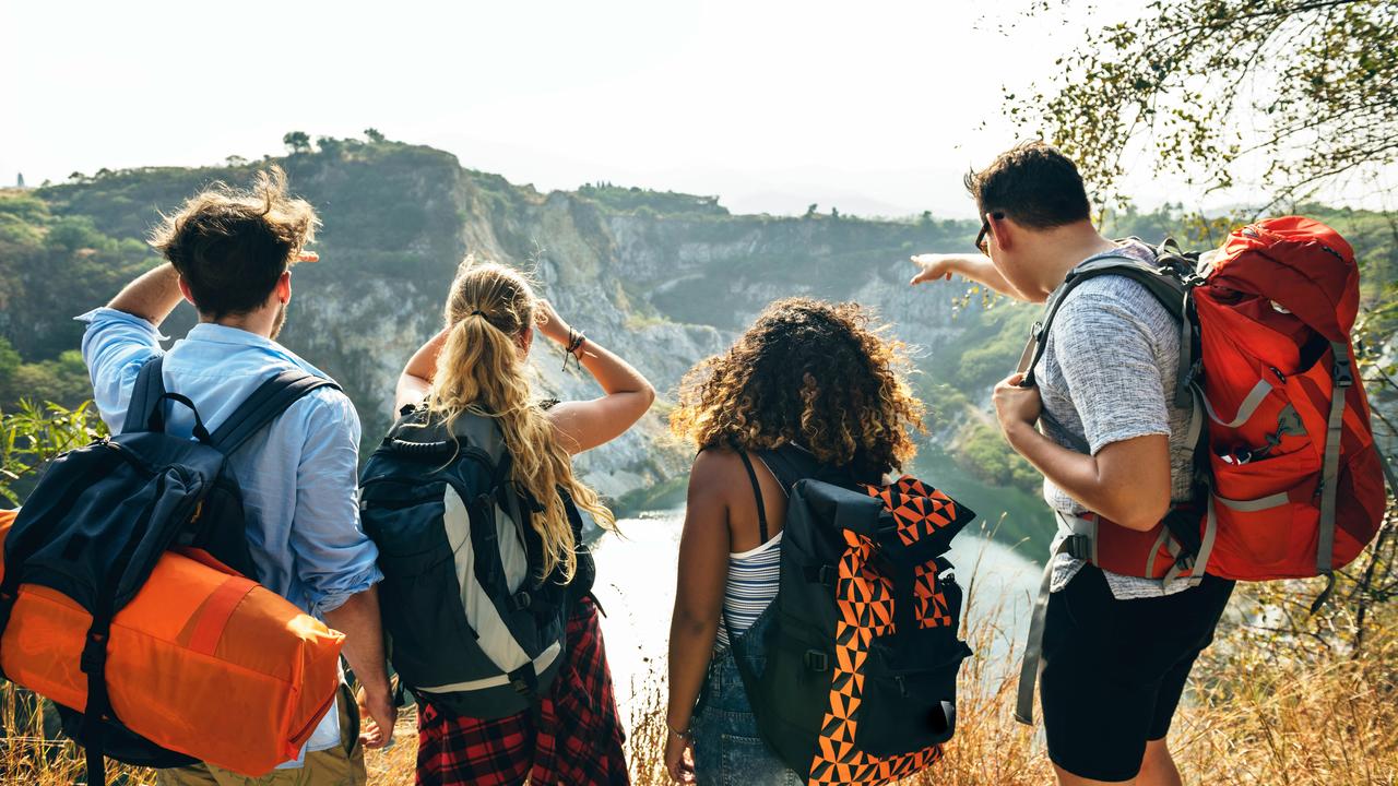 A group of hikers with backpacks overlooking a valley.