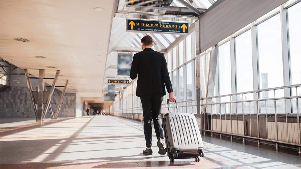 A traveler pulling a suitcase in a train station.