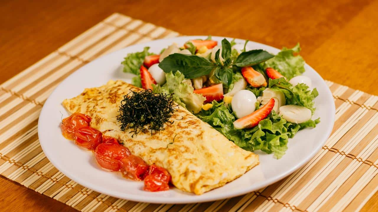 An omelet with salad on a plate.