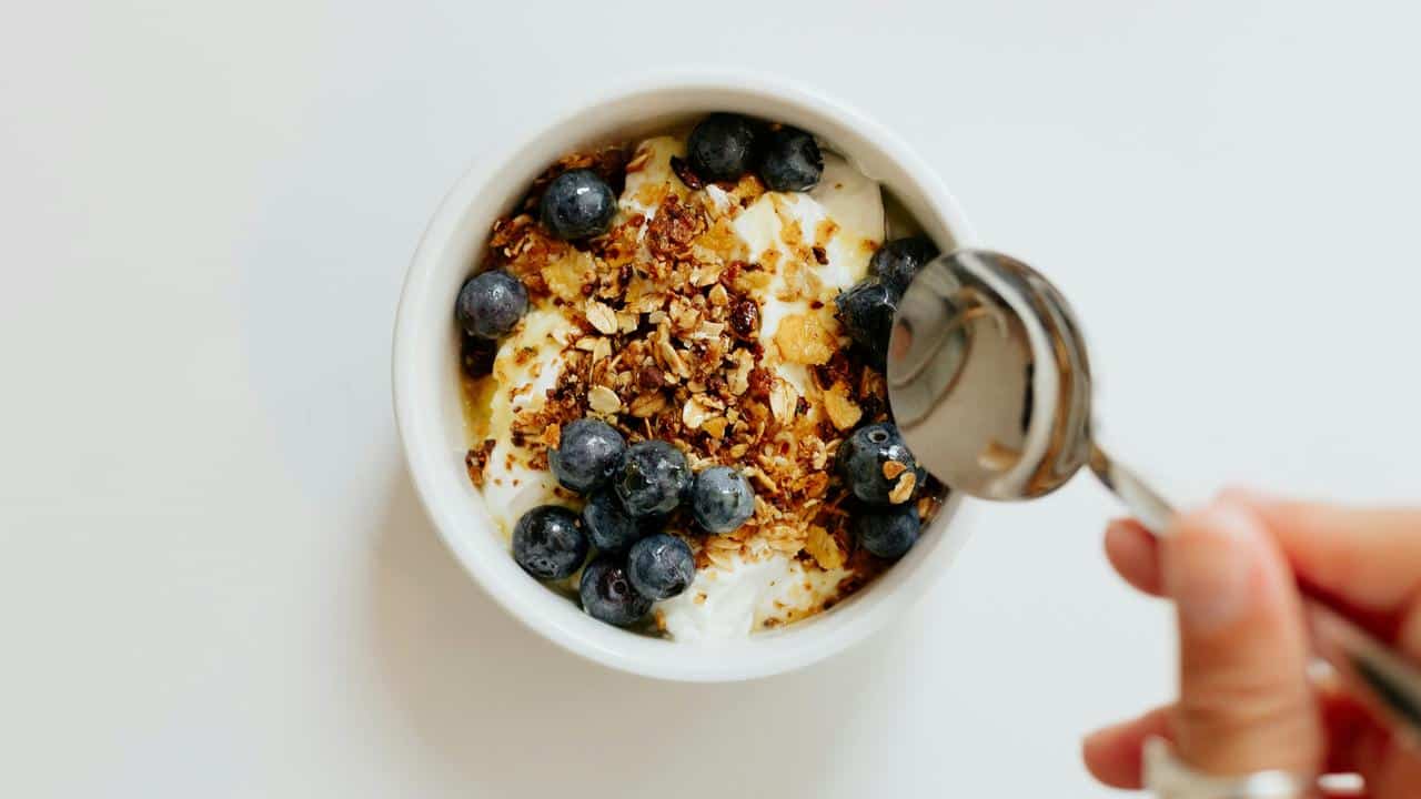 A bowl of yogurt with blueberries and granola.