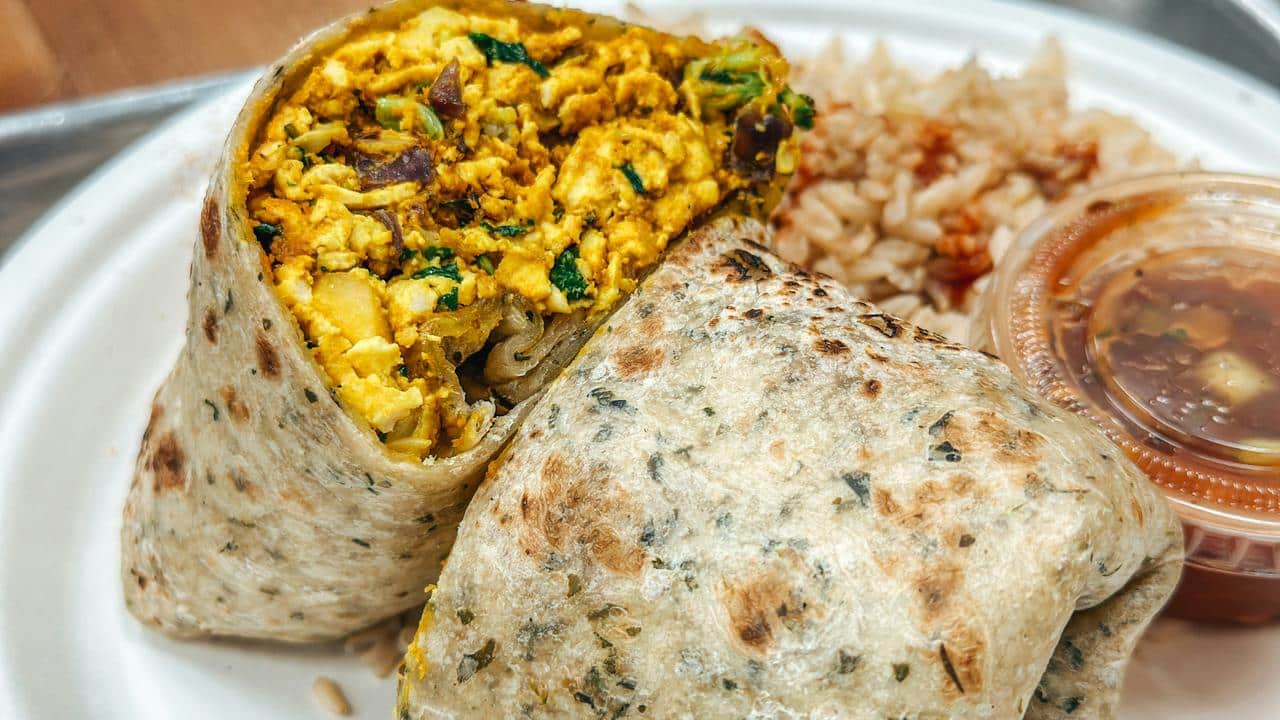 A burrito cut in half on a plate.