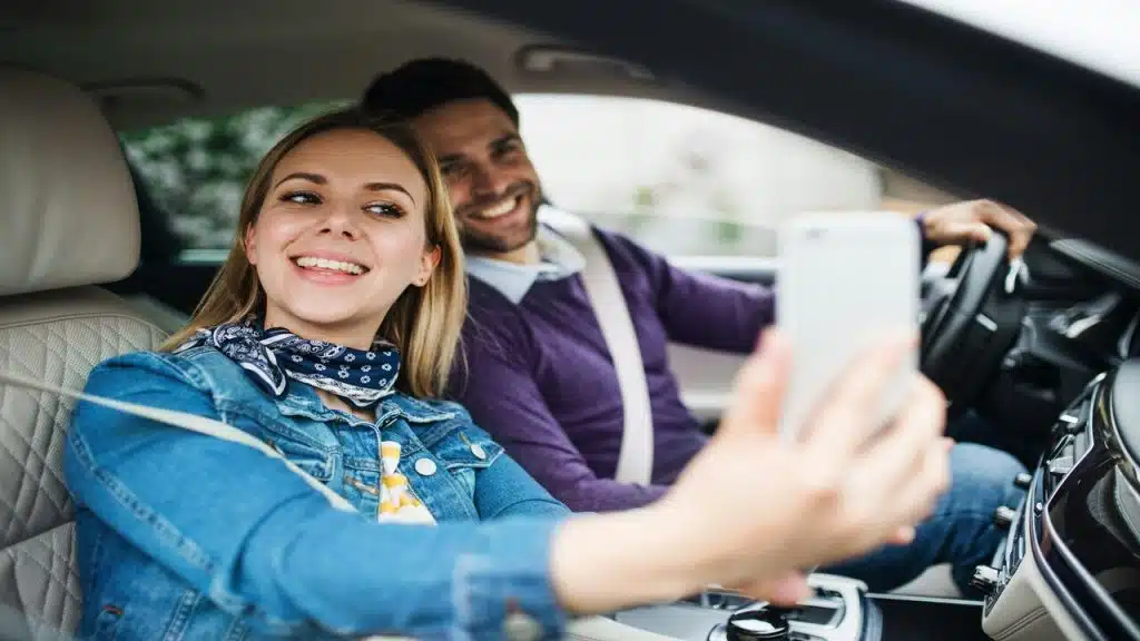 A couple taking a selfie in the car