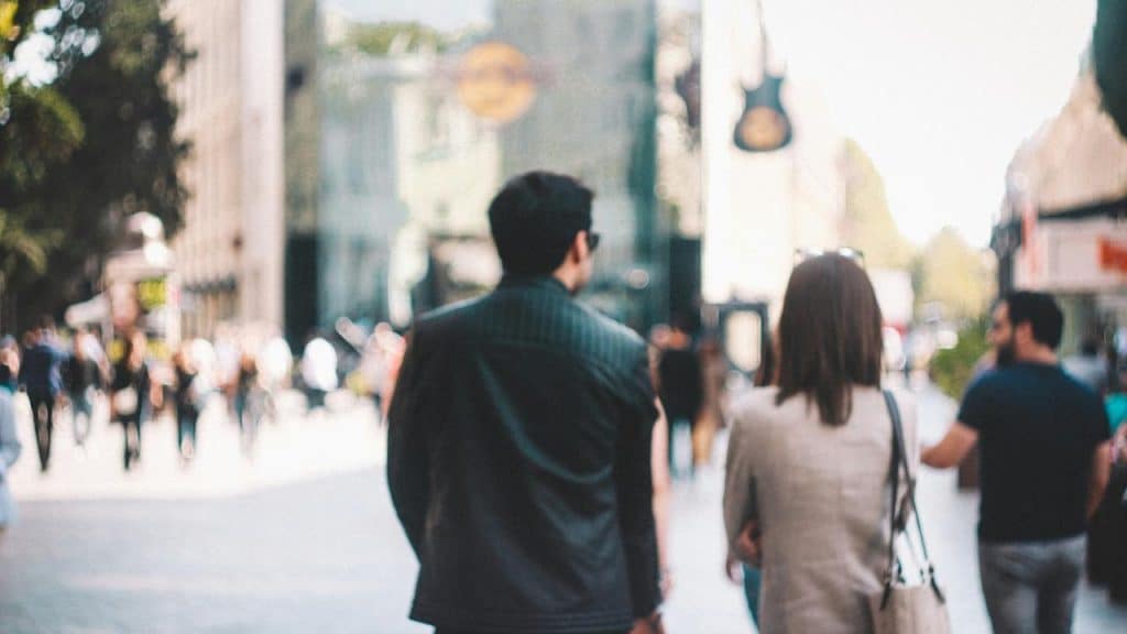 A man and woman walking together down a busy city street.