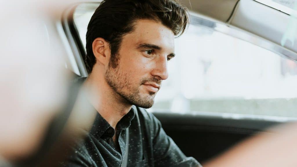 A man in a car looking ahead.