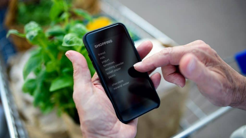 A person using a shopping list on a smartphone.