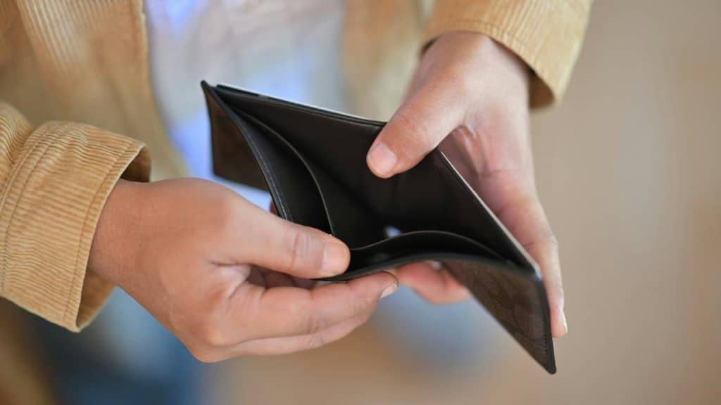 An empty wallet being held open by a person.