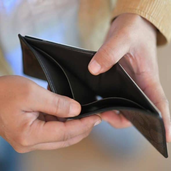 An empty wallet being held open by a person.