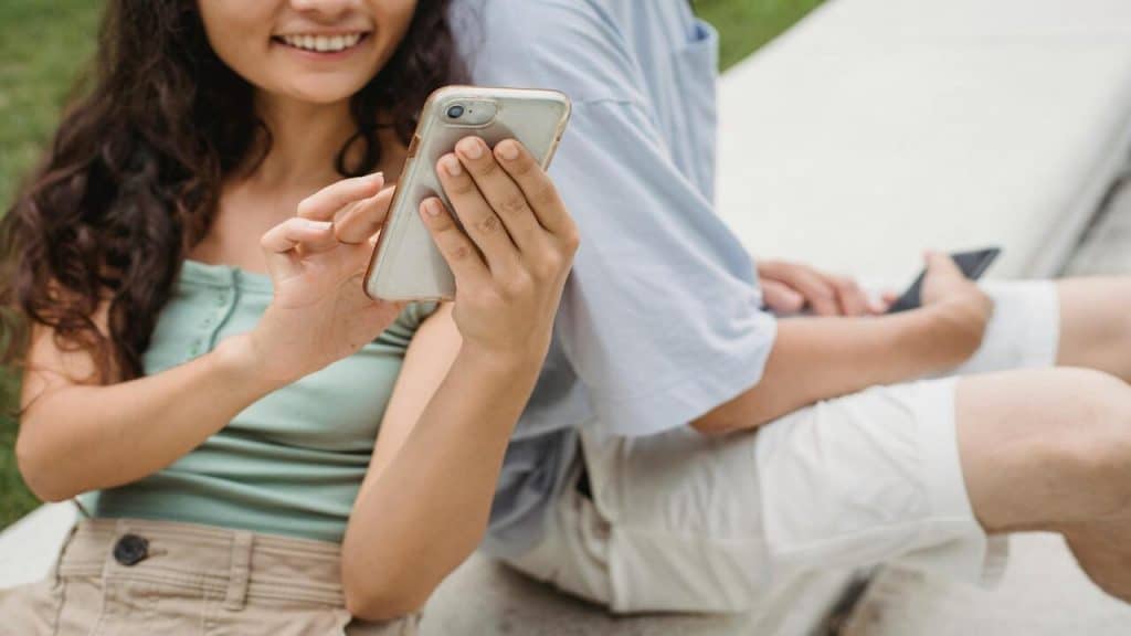 A woman looking at her phone beside her boyfriend