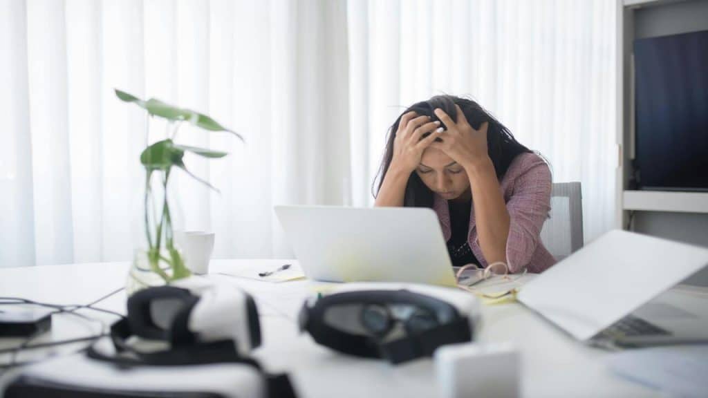 A woman looking stressed in front of the laptop