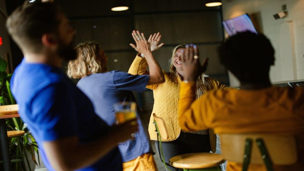 A group of people high-fiving at work.