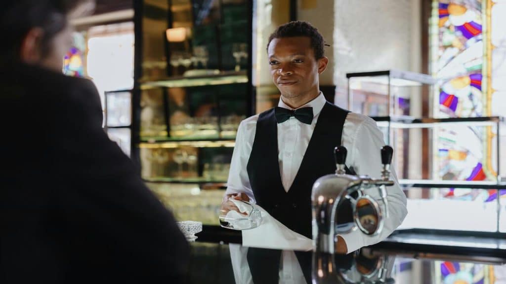 A businessman looking at a bar man.