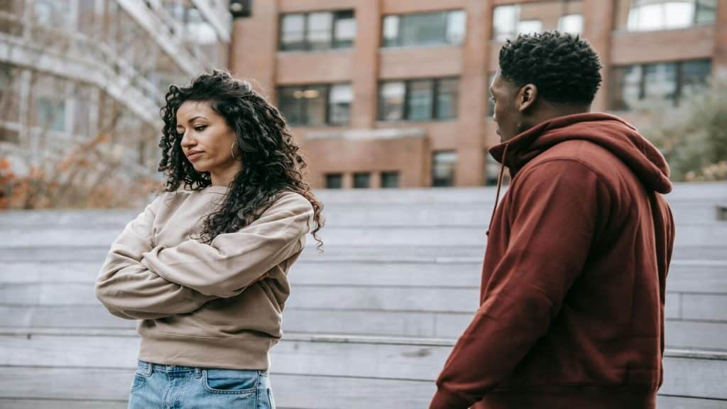 A couple arguing outdoors.