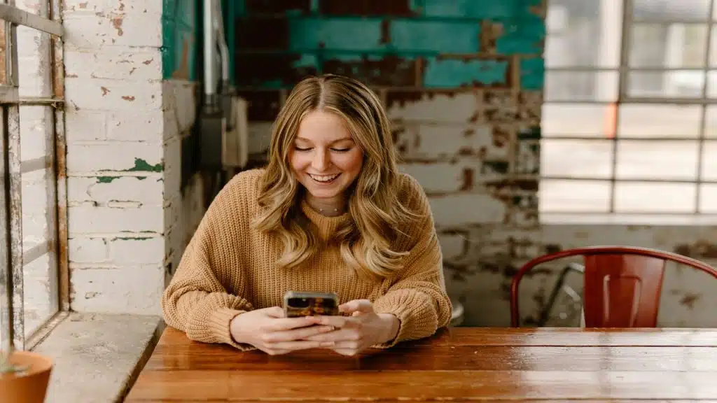 A woman texting at a cafe.