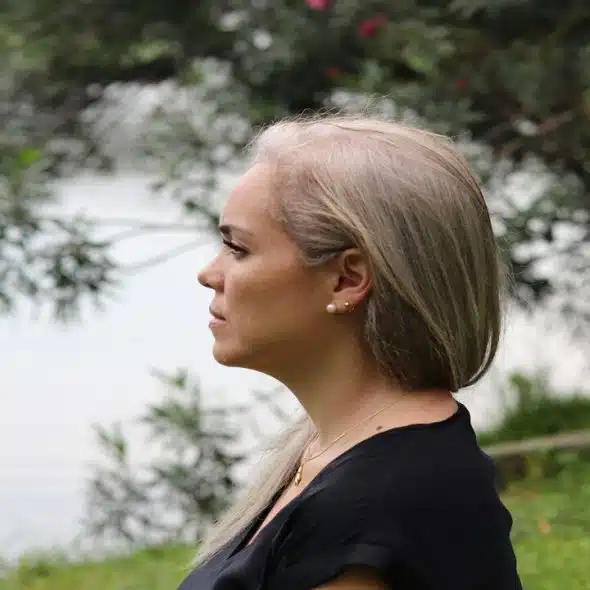 A woman looking sad by a body of water