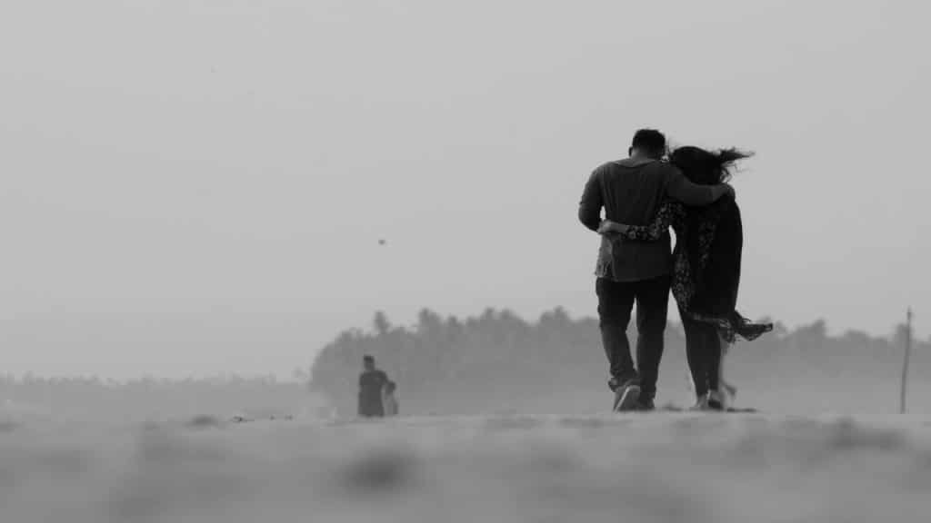 A couple walking with their arms around each other